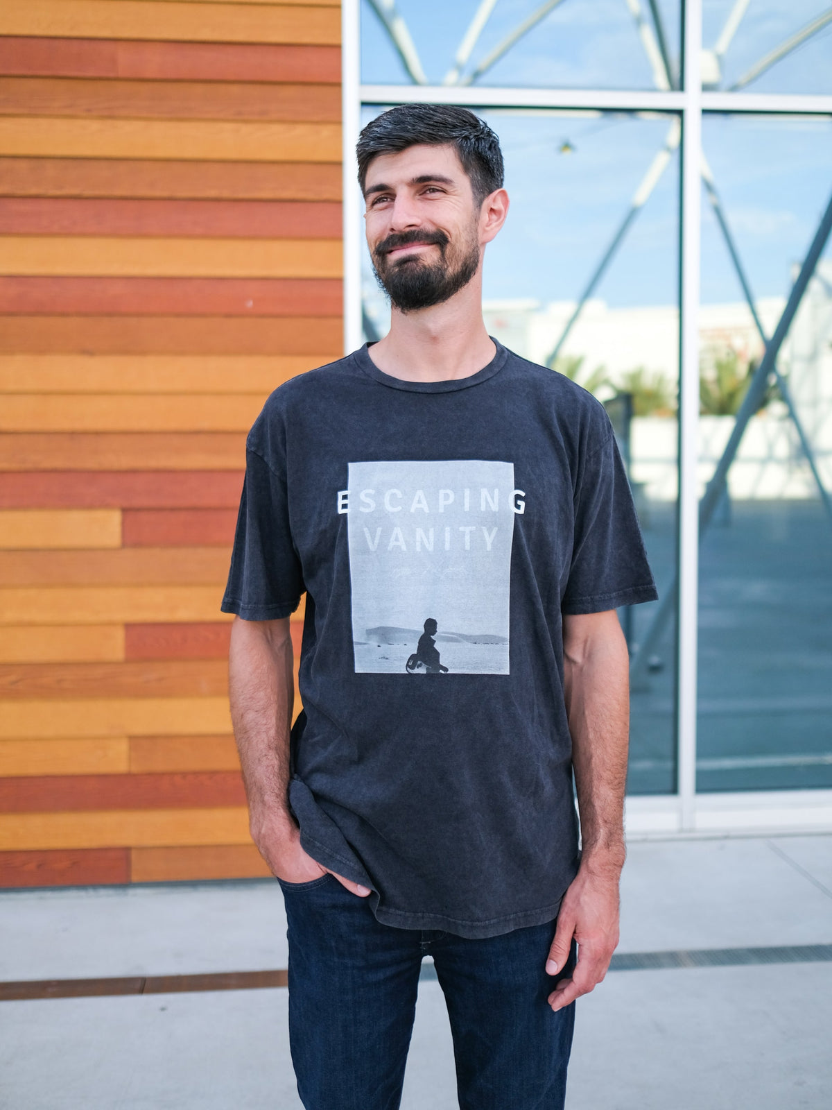 Christian Apparel - This "Band style Tee" is inspired by Ecclesiastes and the 'vanity of vanities' phrase repeated. We wanted to create a product that focuses on Escaping Vanity so we printed on this black washed tee those words along with a picture of a man walking in the dessert with his guitar.